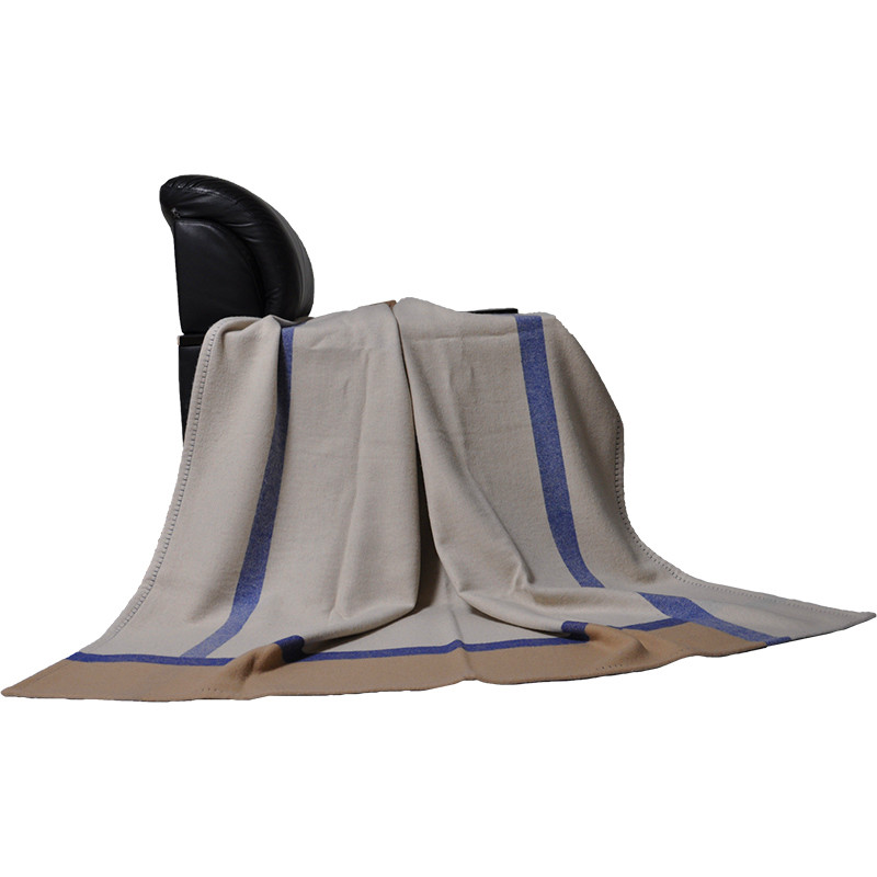 Front view of the Q0192-A 100% lambswool blanket with natural folds, blue border stripes and four-sided stitched edging.