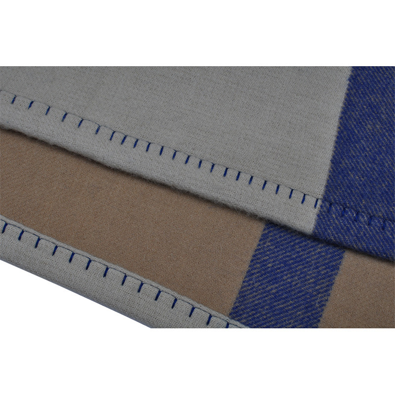 Close-up of Q0192-A lambswool blanket showing soft woven texture, blue stripe and evenly spaced contrast blanket stitching.