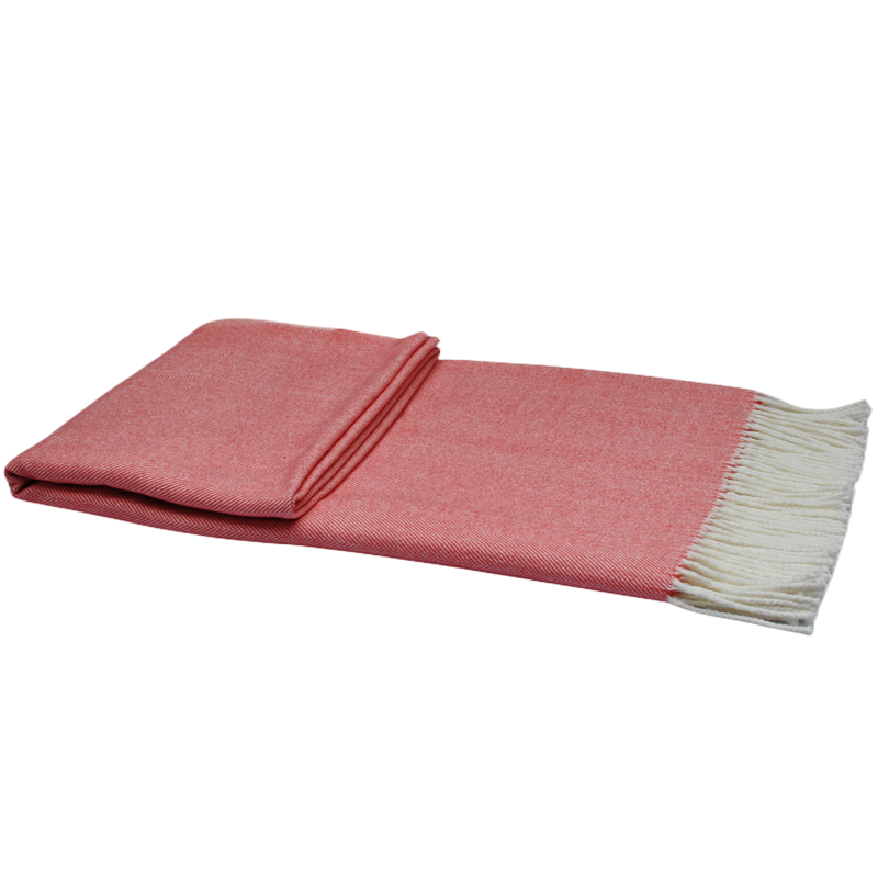 Folded coral herringbone cotton-acrylic throw blanket with white fringe.
