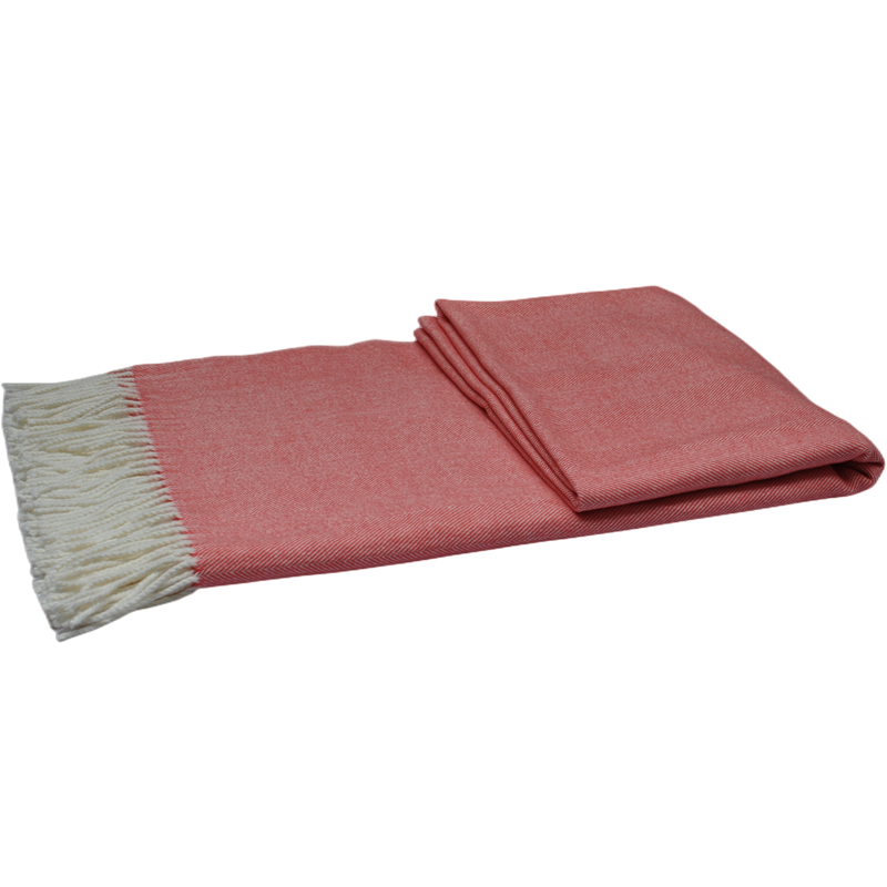 Folded coral herringbone throw blanket, angled view highlighting fabric texture.