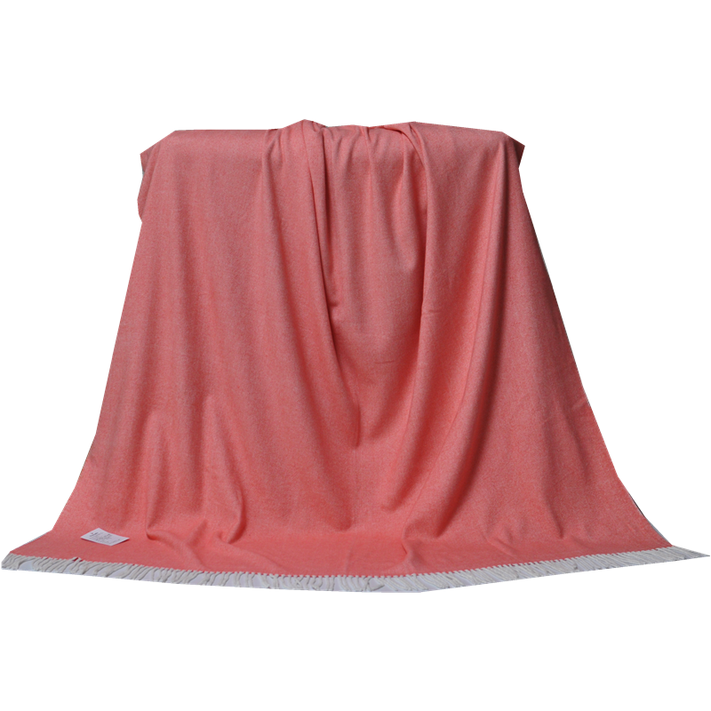 Front view of a coral herringbone cotton-acrylic blanket draped over furniture.