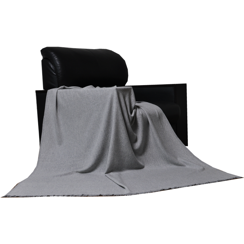 Light grey TH2207 pure cashmere blanket elegantly draped over a black lounge chair.