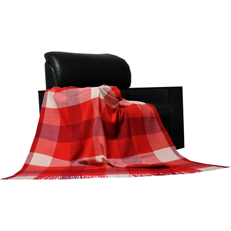 Red and white buffalo check wool throw draped over a black leather sofa.
