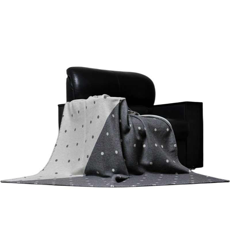 Grey wool dot blanket draped on leather sofa