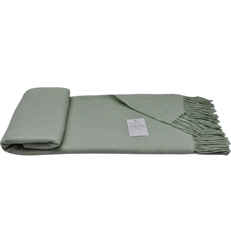E1108 lightweight cashmere wool blanket partially rolled to display its woven surface and fringe.