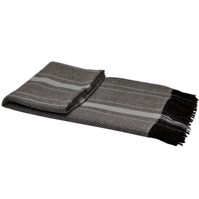 Folded striped wool blend throw blanket with decorative fringe, premium B2B wholesale textile.