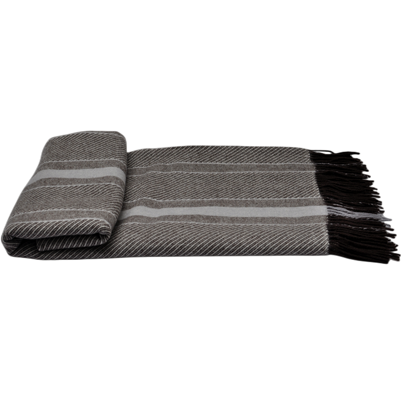 Close-up of folded cashmere and wool blend throw with reversible stripe pattern.