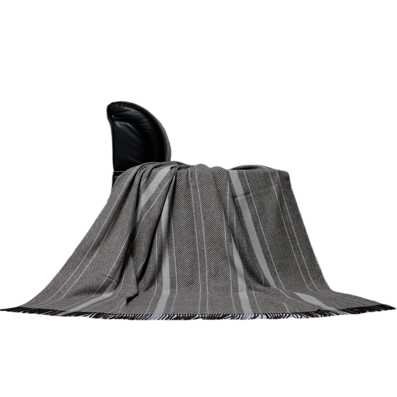 Reversible striped wool throw blanket styled on furniture, premium textile customization.