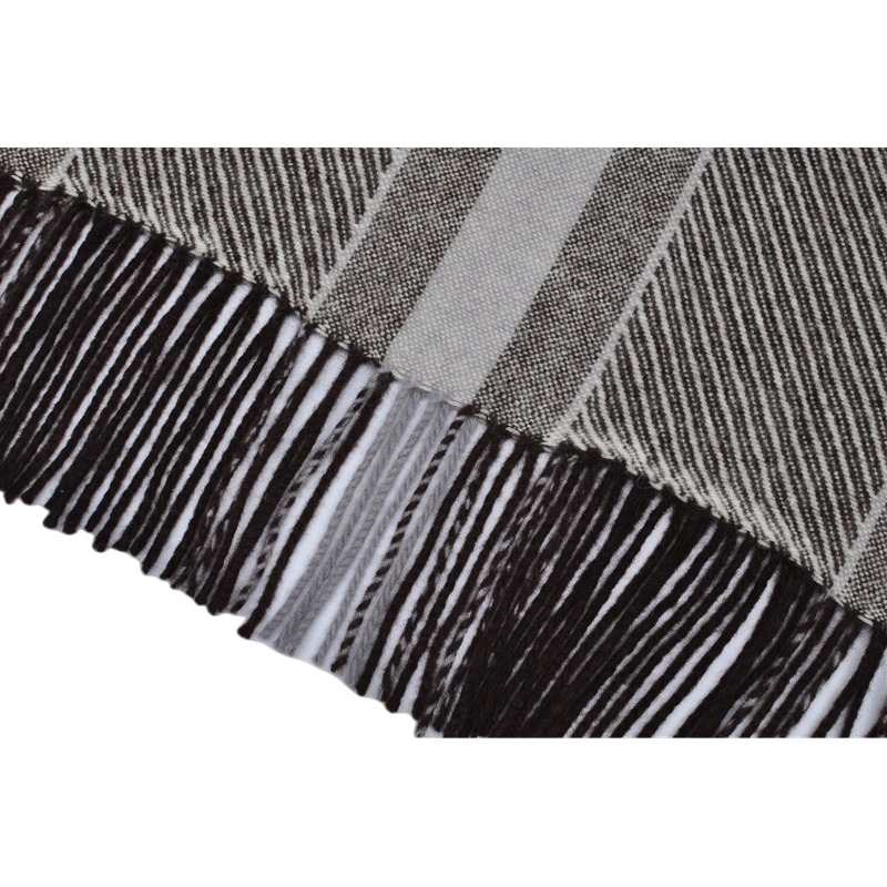 Close-up of high-quality decorative fringe on a striped wool blend throw blanket.