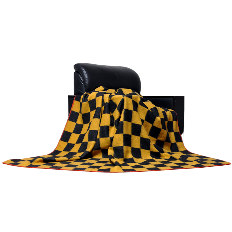 TBT1804 yellow and black checkerboard wool blanket naturally draped over a black chair to display its heavyweight texture