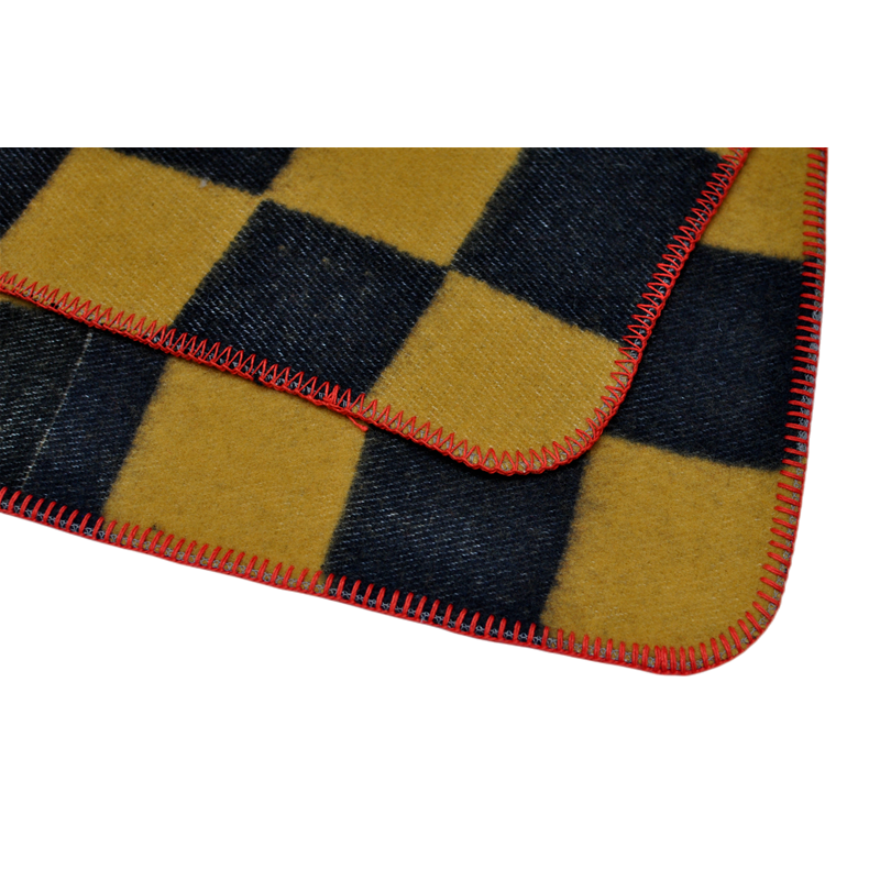 TBT1804 Australian wool blanket corner detail showing the checkerboard design and contrasting red overlock stitching