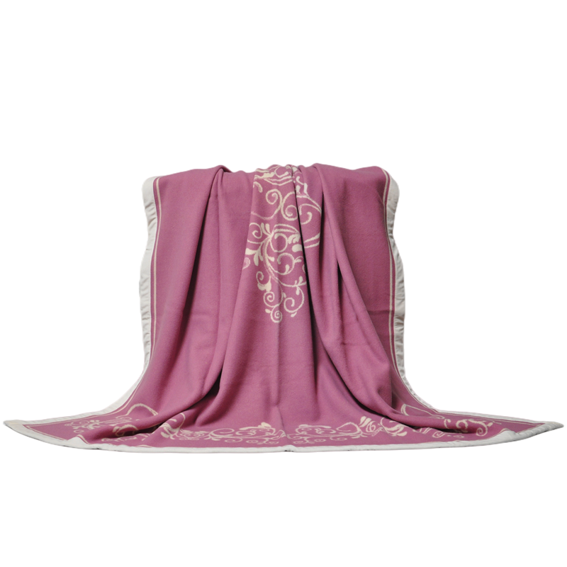 The LL1101 luxury Merino wool blanket partially spread to reveal the pink and white Damask Scroll jacquard.