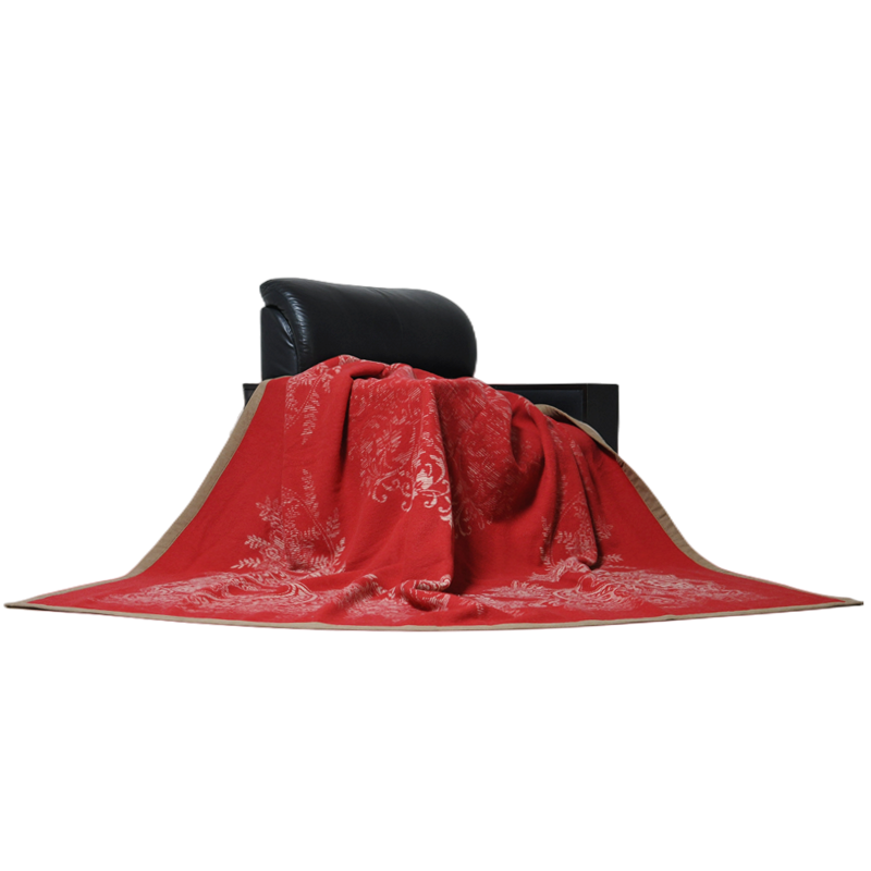 Red floral wool blanket draped on leather sofa home styling