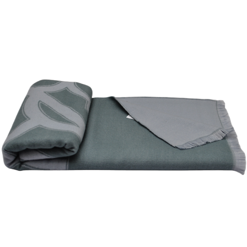Partially rolled TDX2203 grey-green geometric patterned throw blanket showing its double-sided texture and fringe design.