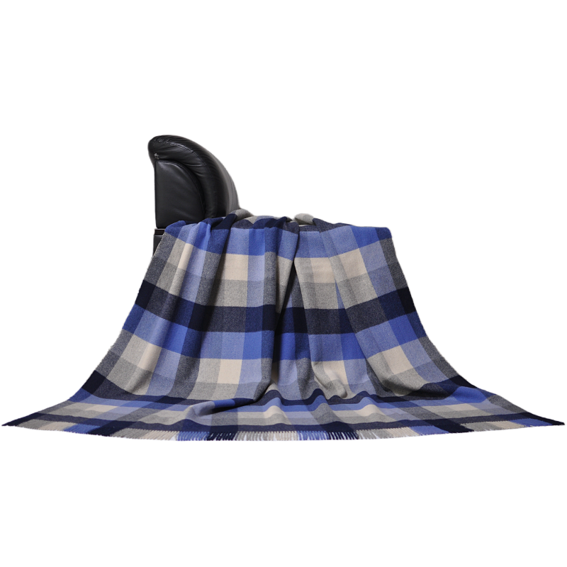 Side view of K1003 1090g heavyweight plaid wool blanket draped on couch showcasing premium texture and soft drape