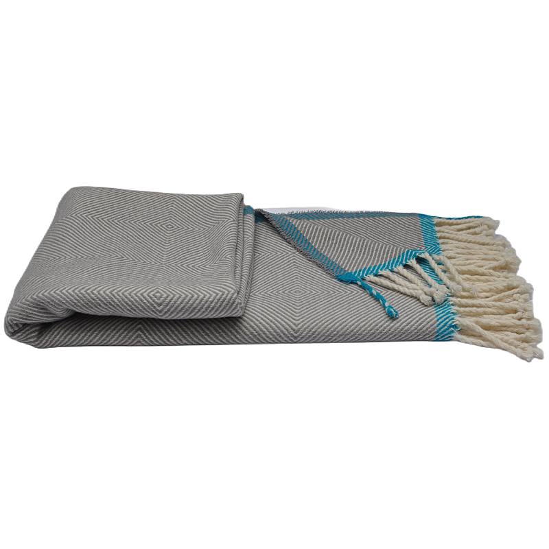 Folded grey wool herringbone throw blanket with decorative tassels