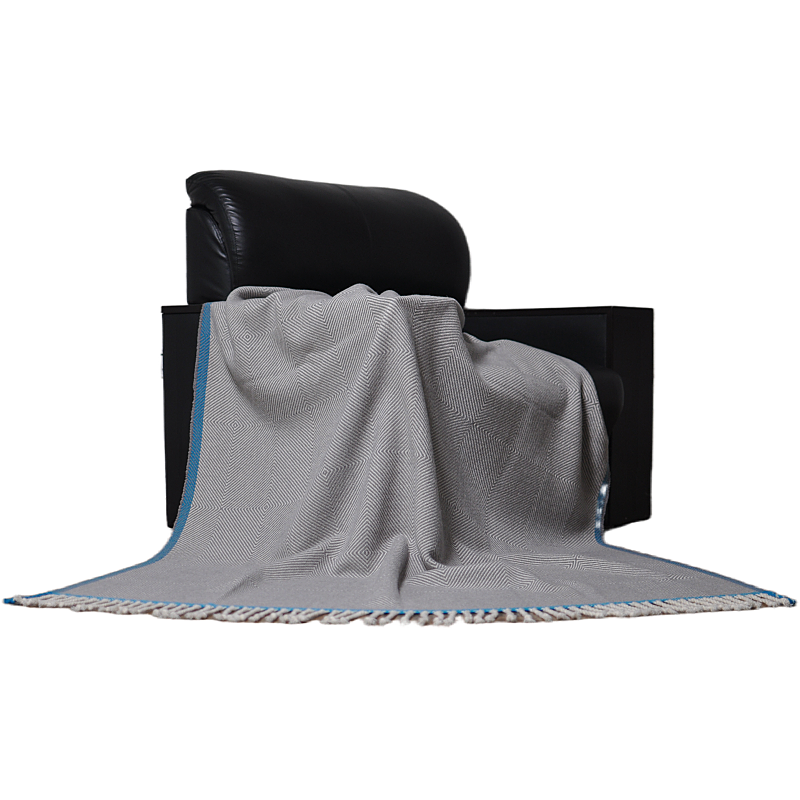 Grey herringbone nested chevron wool throw blanket draped over a chair