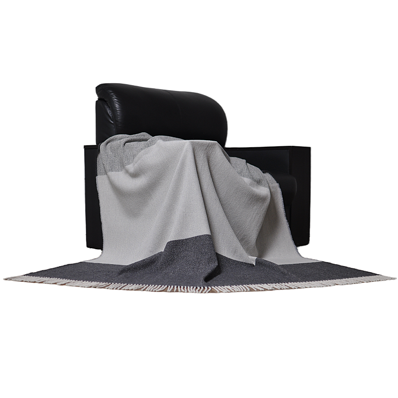Grey color block wool fringed blanket on black sofa home decor
