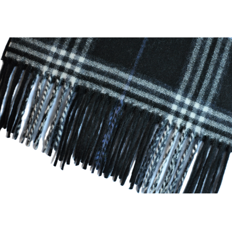 Macro detail shot mixed black white tassel fringe edge of black tartan wool cashmere scarf woven texture