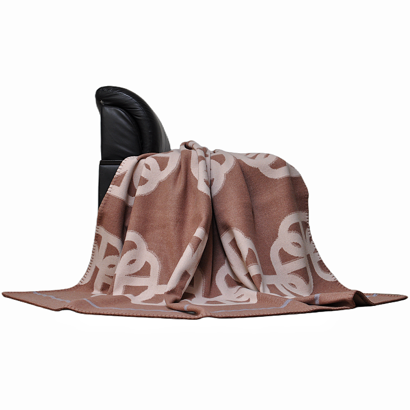 TAK2260 reversible geometric wool blanket displayed naturally on a contemporary black chair