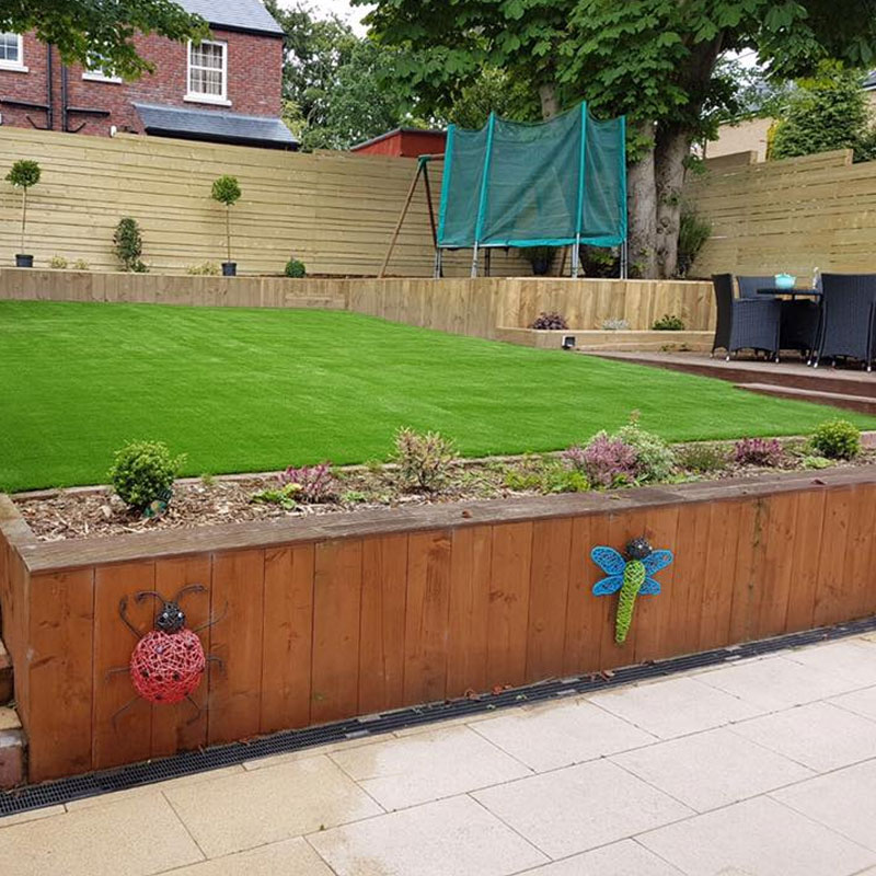 laying artificial grass on soil on a slope